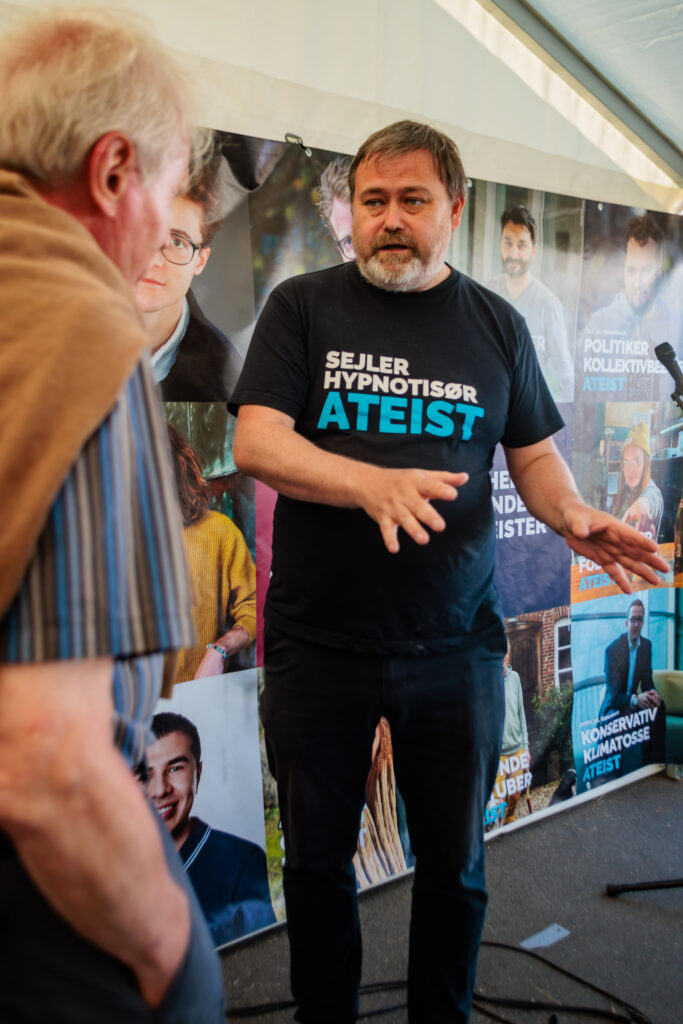 David forklarer iført sin ATEIST t-shirt med teksten sejler, hypnotisør, ateist