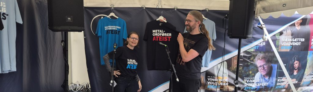 Stinus Lindgreen, folketingsmedlem for Radikale Venstre og entusiatisk fan af metalmusik. Mand i 40erne med langt hår. Viser smilende sin nye Metalordfører ATEIST tshirt frem under samtale med Lena Nyhus om sekularisering.